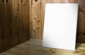 Blank white poster leaning at wooden wall in dark plank wood room,Mock up for adding your content Royalty Free Stock Photo