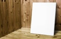 Blank white poster leaning at wooden wall in plank wood room,Mock up for adding your content. Royalty Free Stock Photo