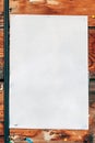 Blank white poster paper mockup stapled to a wooden background Royalty Free Stock Photo