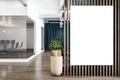 Blank white poster on wooden partition in stylish office space with tree in a flowerpot on wooden parquet and work place behind a