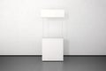 Blank white promo counter mockup stand near the wall