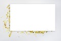 Blank white rectangular card on gold confetti. Space for inscription or design. Top view. Mock up. Royalty Free Stock Photo