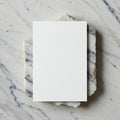 A blank white rectangular card rests on a slab of textured marble with gold edges. The Royalty Free Stock Photo