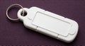 Blank White Rectangular Key Tag with Silver Ring on Textured Purple Background Royalty Free Stock Photo