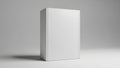 A blank white rectangular product box or book mockup stands vertically on a neutral surface in a clean studio setting with soft Royalty Free Stock Photo