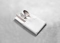 Blank white restaurant cloth napkin mock up with silver cutlery