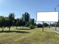 Blank white road billboard in city in summer sunny day. Street advertising poster, mock up, Glued paper mockup Royalty Free Stock Photo