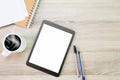 Blank white screen tablet computer with hot coffee cup, papers, notebook and pens on wooden desk Royalty Free Stock Photo