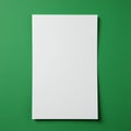 A blank white sheet of paper is centered on a textured green surface. The paper is Royalty Free Stock Photo