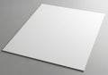 A blank white sheet of paper lies on a gray surface, viewed from a slight angle Royalty Free Stock Photo