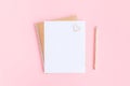 Blank white sheet on spiral golden notepad with paper clip heart and pencil on pink pastel background. Mock up for your text and Royalty Free Stock Photo