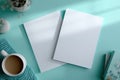 Generative AI Blank White Paper Sheets on Light Turquoise Surface with Shadow and Coffee business concept. Royalty Free Stock Photo