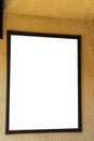 Blank white sign in brown frame on golden yellow wall. Royalty Free Stock Photo