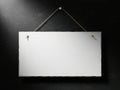 Blank white sign hanging on a dark wall with two nails Royalty Free Stock Photo