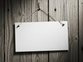 Blank white sign hanging on rustic wooden wall with metal string Royalty Free Stock Photo