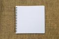 Blank white sketch book on hessian texture background