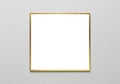 A blank white square with a thin, gold metallic frame is centered on a textured gray wall. The Royalty Free Stock Photo