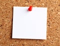 A blank white sticky note with deep red bold handwriting pinned to a corkboard square Royalty Free Stock Photo