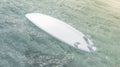 Blank white surfboard with fins on water surface mockup