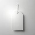 A blank white tag hanging from a silver chain against a grey background Royalty Free Stock Photo