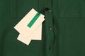 Blank white tags on green shirt, top view. Space for text Royalty Free Stock Photo