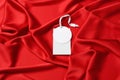 Blank white tags on red silky fabric, top view. Space for text Royalty Free Stock Photo