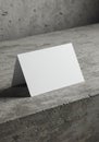 A blank, white tent card stands on a textured concrete surface. The card is crisply Royalty Free Stock Photo
