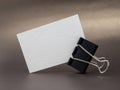 Blank textured business card held by binder clip on a brown surface Royalty Free Stock Photo