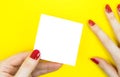 Blank white To Do List Sticker in woman hand. Close up of reminder note paper on the yellow background. Copy space. Minimalism, Royalty Free Stock Photo