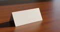 A blank, white, triangular tent card placed on a polished wooden surface. The card is Royalty Free Stock Photo