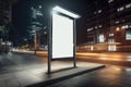 Blank white vertical digital billboard poster on city street bus stop sign at night. AI generated Royalty Free Stock Photo