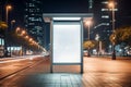 Blank white vertical digital billboard poster on city street bus stop sign at night Royalty Free Stock Photo