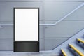 Blank white vertical digital display in front of painted concrete wall, beside flight of stairs. Template for mock up of