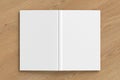 Blank white vertical open and upside down book cover on wooden background isolated with clipping path around cover. Royalty Free Stock Photo