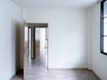 Blank white wall background in the empty room near the wooden opened door near the window with copy space. Royalty Free Stock Photo