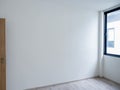 Blank white wall background in the empty room near the wooden opened door near the window. Royalty Free Stock Photo