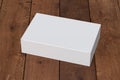 Blank white wide flat box with closed hinged flap lid on dark wooden background. Royalty Free Stock Photo