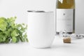 Blank white wine tumbler mockup with greenery, wine bottle , bottle opener and wine bottle cork. Royalty Free Stock Photo