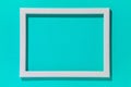 Blank white wooden frame on turquoise background. Mockup design. Royalty Free Stock Photo