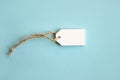 Blank white wooden price tag or label isolated on light blue background