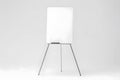 A blank whiteboard on a tripod stand is set against a plain grey background. Royalty Free Stock Photo