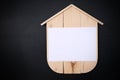 Blank Wood House with blank paper on black background. Concept sale, construction of ecological houses and discounts