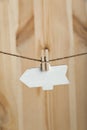 Blank wooden arrow pointer hang with clothespins on rope on wooden background. Copy space. Place for your text Royalty Free Stock Photo