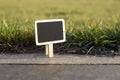 Blank wooden blackboard label in front of grass background Royalty Free Stock Photo