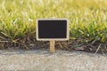 Blank wooden blackboard label in front of grass background Royalty Free Stock Photo