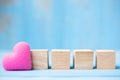 Blank wooden cubes with pink heart shape decoration on blue table background and copy space for text. Love, Romantic and Happy Royalty Free Stock Photo