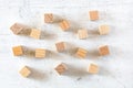 Blank wooden cubes scattered on white stone board, flat lay photo