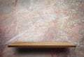 Blank wooden display shelf on marble wall Royalty Free Stock Photo