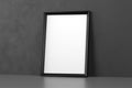 Blank wooden picture frame leaning over dark wall Royalty Free Stock Photo