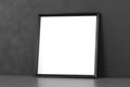 Blank wooden picture frame leaning over dark wall Royalty Free Stock Photo